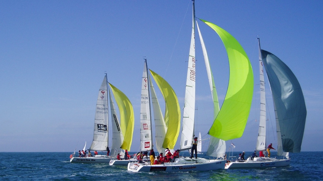 A fleet of Grand Surprise boats under spinnaker
